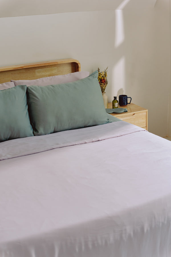 Bedroom with light purple and green bedsheets